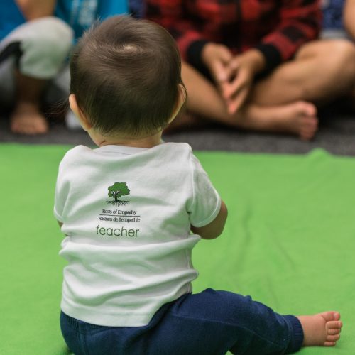 baby with Roots of Empathy t shirt sitting
