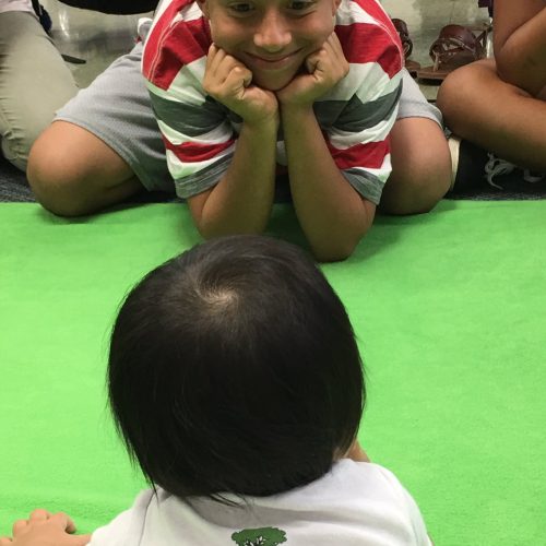 a baby and a student look at each other