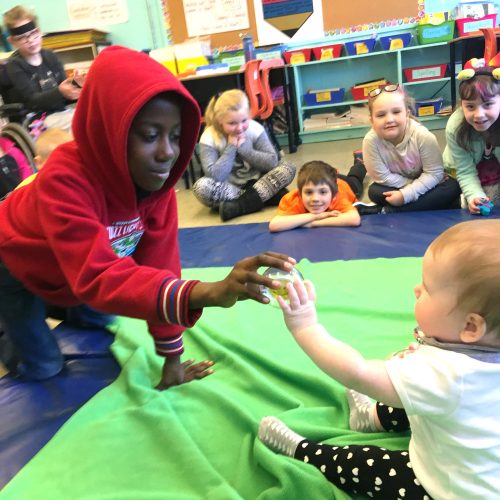 a student plays with a baby